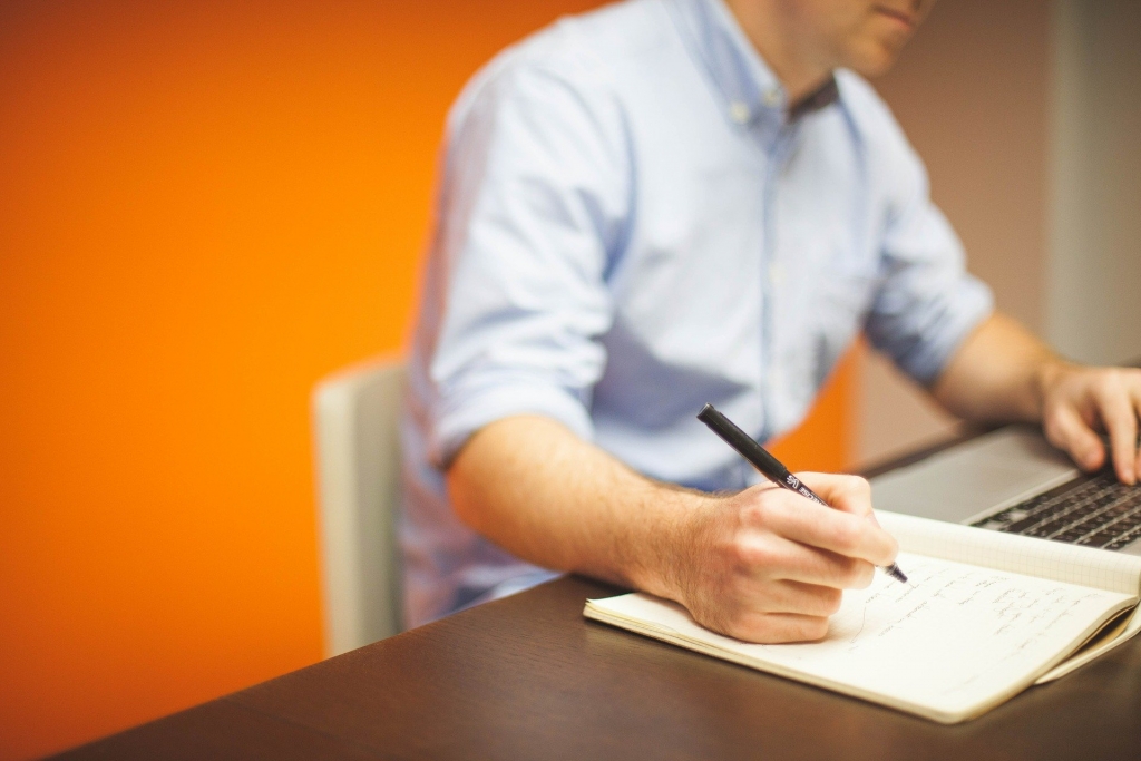 Person writing on a notebook